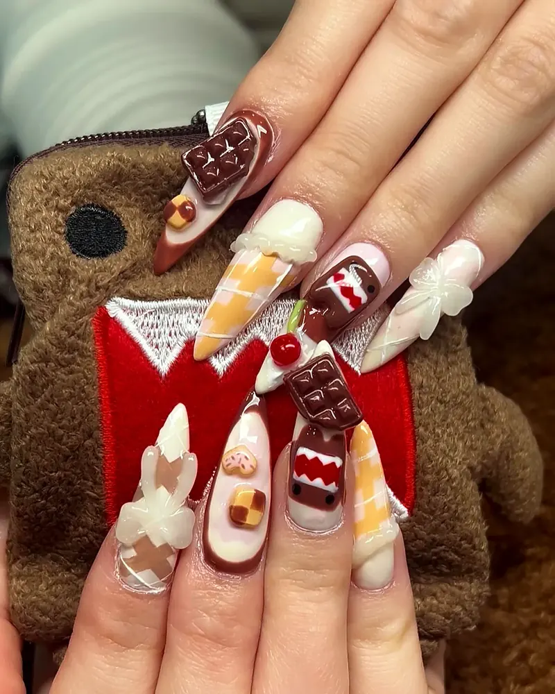 Domo-kun nails: 3D chocolate bars, cherries and Domo's face on long stilettos, next to a Domo plush