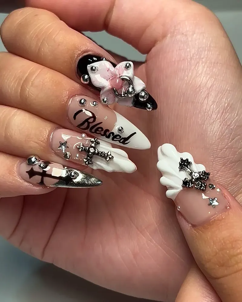 Long almond nails with black and silver chrome crosses, a 3D bow and 'Blessed' lettering