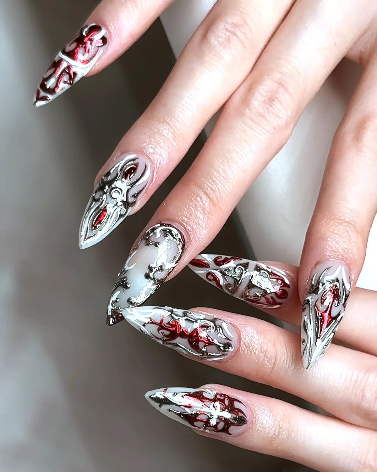 Long stiletto nails with silver chrome and red liner art